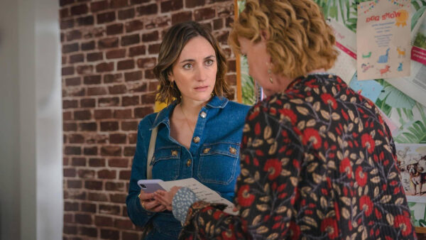 Two women holding and reading a letter