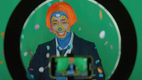 An artist standing behind a camera