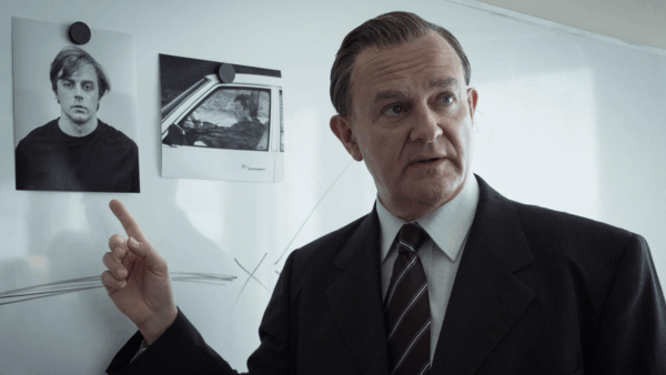 A detective pointing at a board