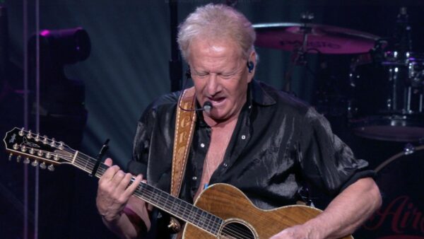 Graham Russel playing the guitar on stage at the 'Air Supply: 50th Anniversary Concert'