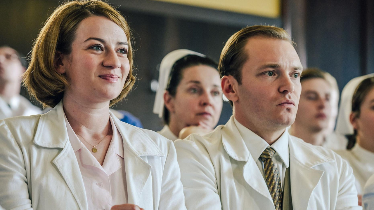 a group of doctors and nurses watching something behind the camera