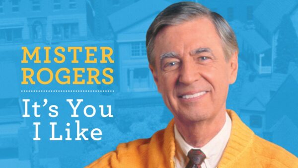 Mister Rogers in a yellow sweater and brown tie