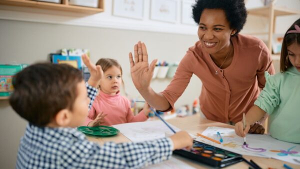 A teacher high fiving a young student