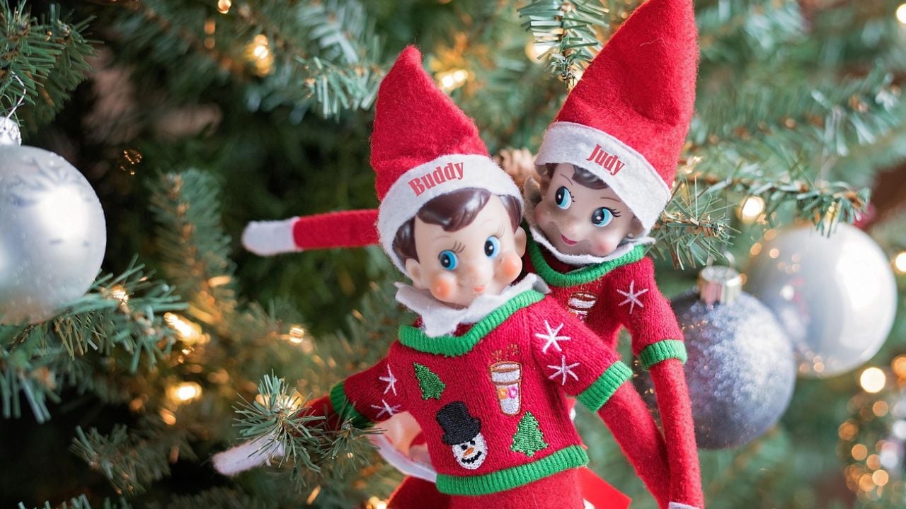 Two toy elves sitting in a Christmas tree