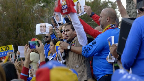 Venezuelans hold signs and banners at a public protest