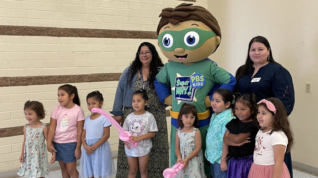 A group of students poses for a photo at a Super Why Reading Camp at their school