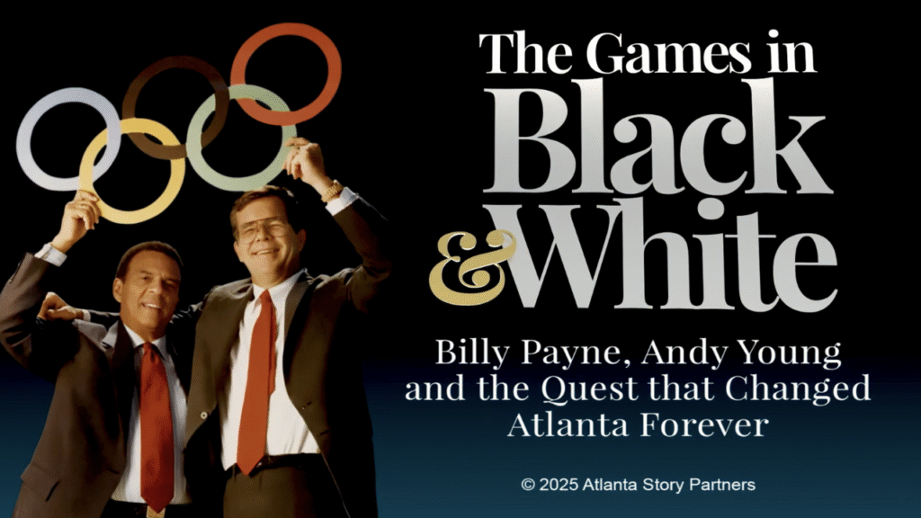 Two men holding up the Olympic rings