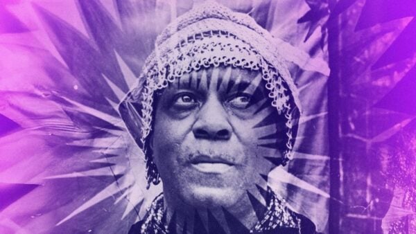 A portrait of a man wearing a lace headscarf