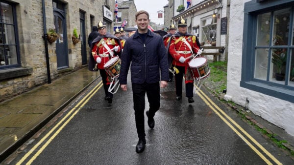 A man walking with a Highland cow