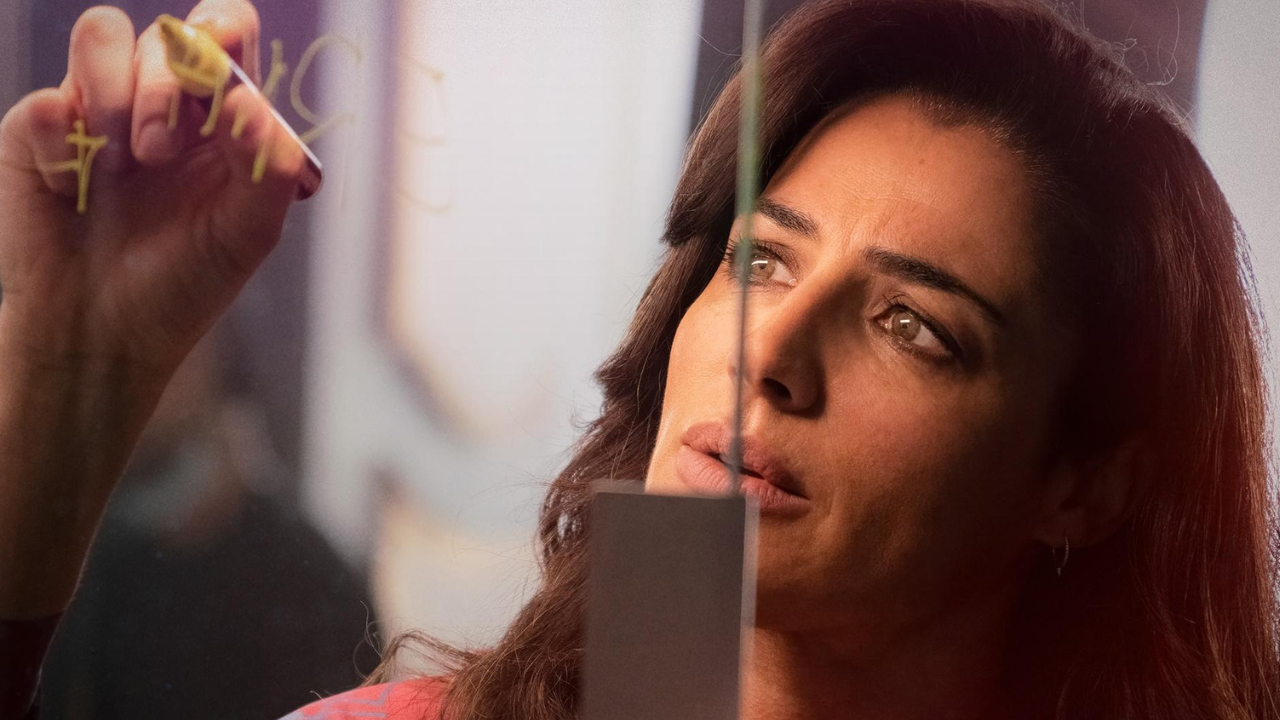 A woman writing on a clear board