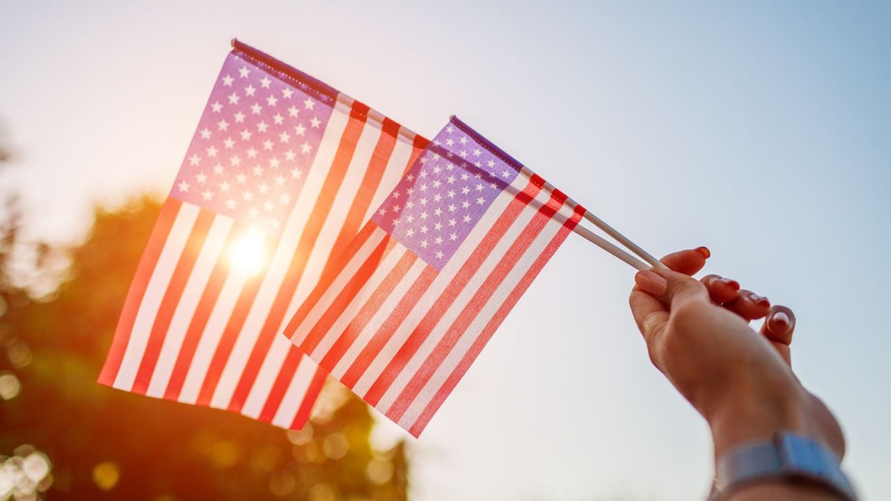 A hand holding two American flags in the air