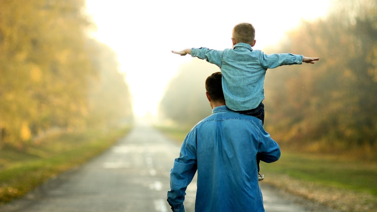 A son rides on his father's shoulders