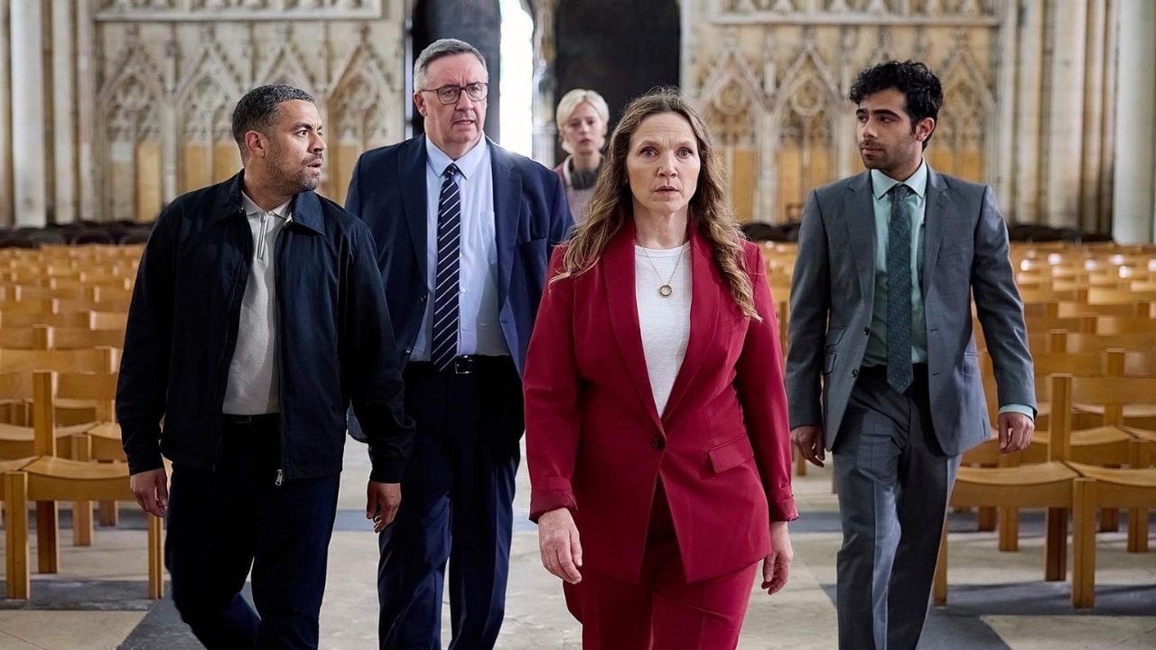 Five characters from Patience walk down an aisle of chairs