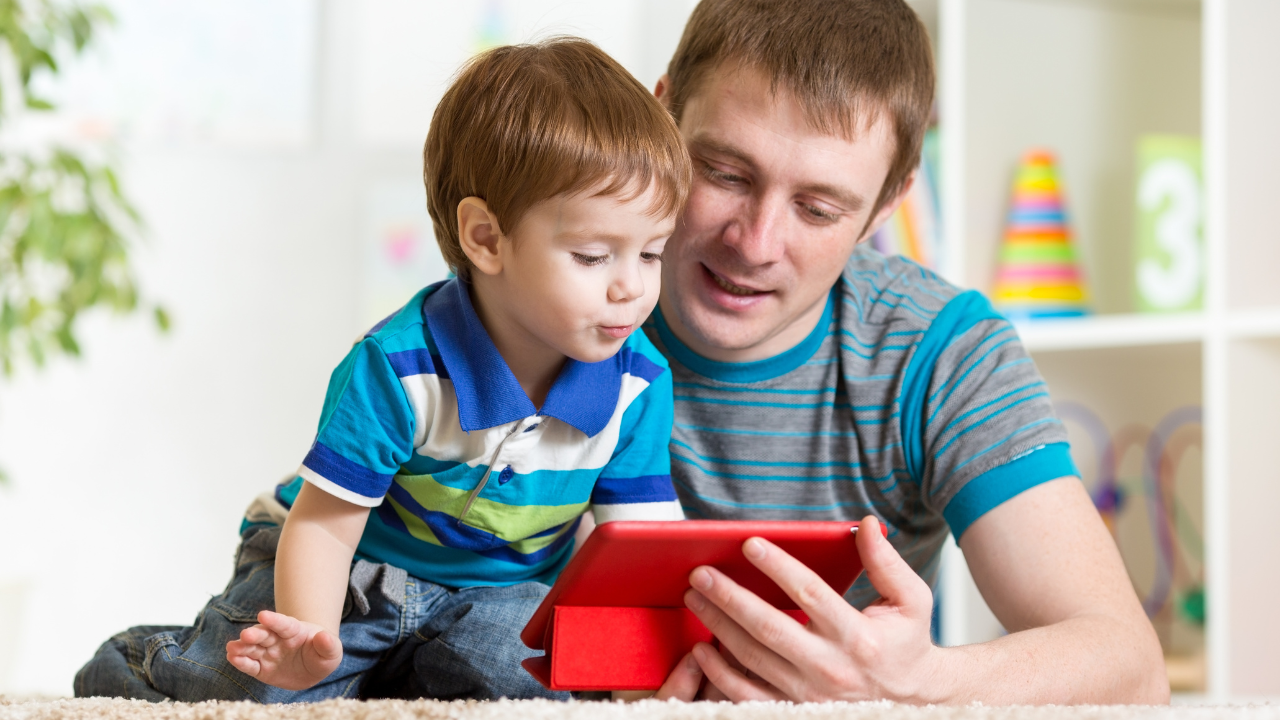 A father and son use a tablet together