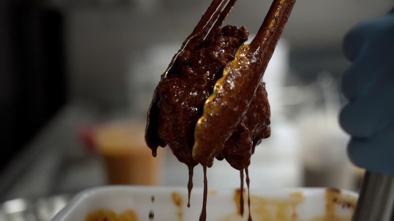 Tongs picking up barbeque meat