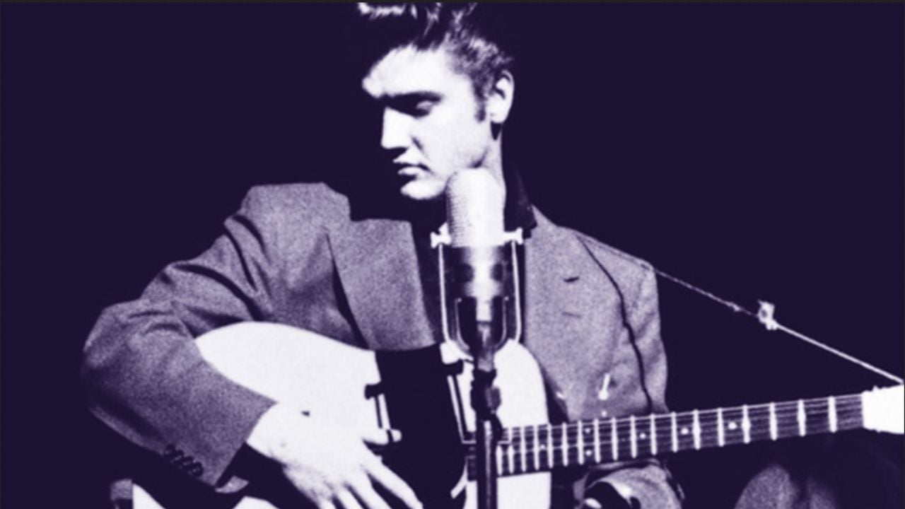 Elvis playing a guitar on stage